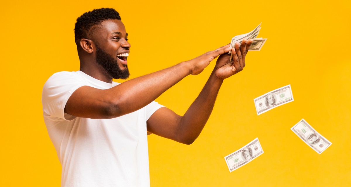 Happy,African,American,Man,Throwing,Out,Money,Banknotes,,Yellow,Studio